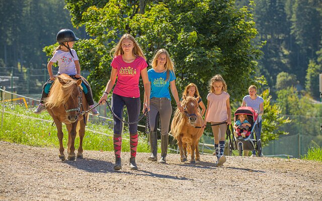 Kinder mit Ponys beim Ponyspaziergang