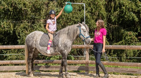 Kind bei Reitstunde im Roundpen