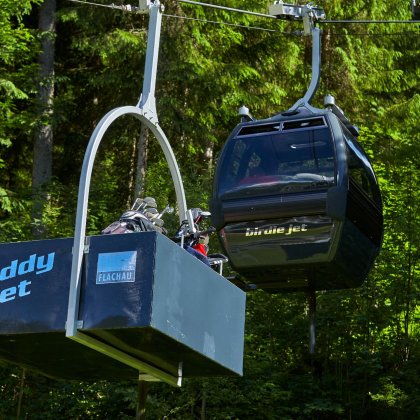 Gondel mit extra Caddy-Lift bringt Golfbags durch den Wald.