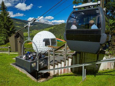 Seilbahn mit Golfbag-Transport an Bergstation mit Golfball-Deko.
