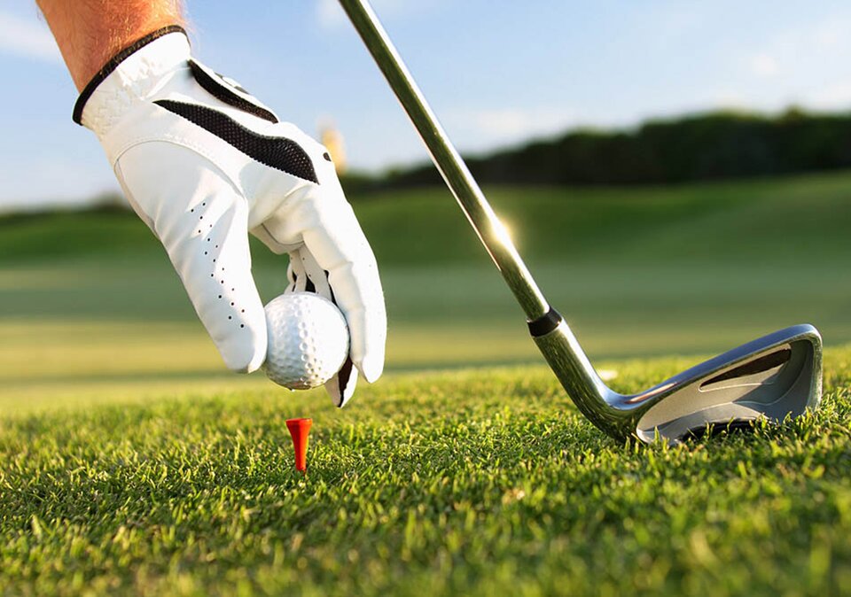 Hand platziert Golfball auf dem Tee