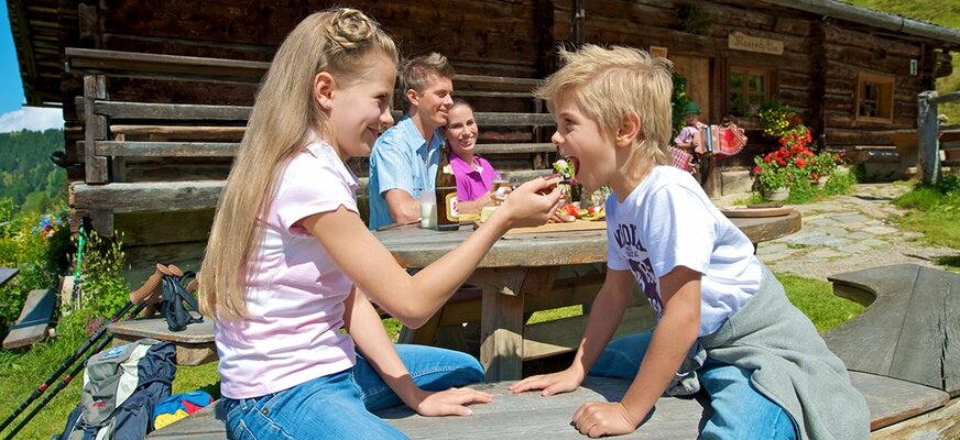 Familie beim Essen auf einer der Almhütten