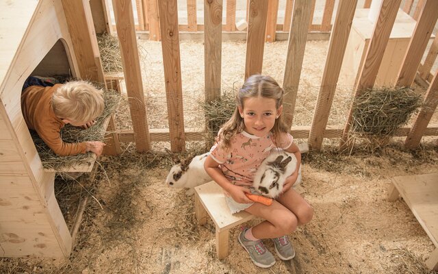 Kinder mit Hasen im Streichelzoo