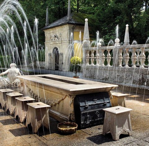 Wasserspiele und Steintisch im Schlosspark Hellbrunn.