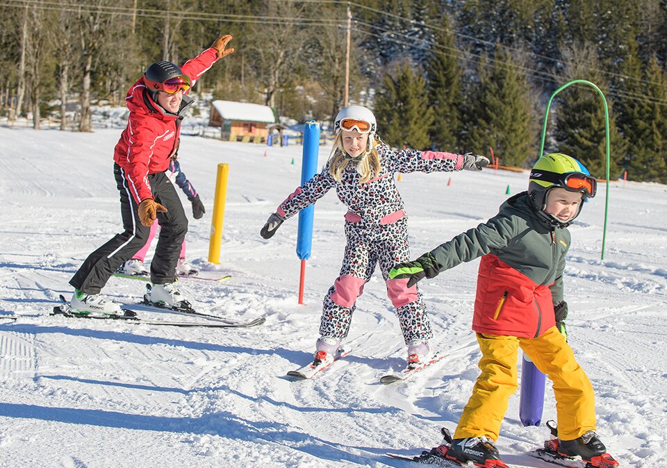 Skilehrer mit Kinder beim Skikurs
