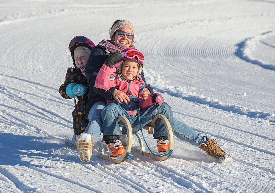 Familie beim Schlitten fahren