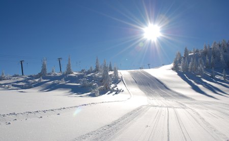 Frisch präparierte Skipiste unter strahlender Wintersonne.