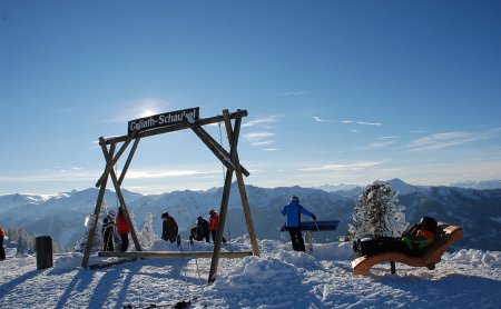 Holzschaukel und Liegen mit Panoramablick in die Berge.