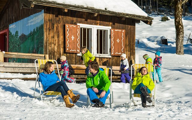 Gäste beim Sonnentanken vor der Hütte