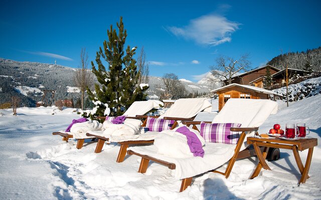 Liegestühle in der sonnigen Schneelandschaft